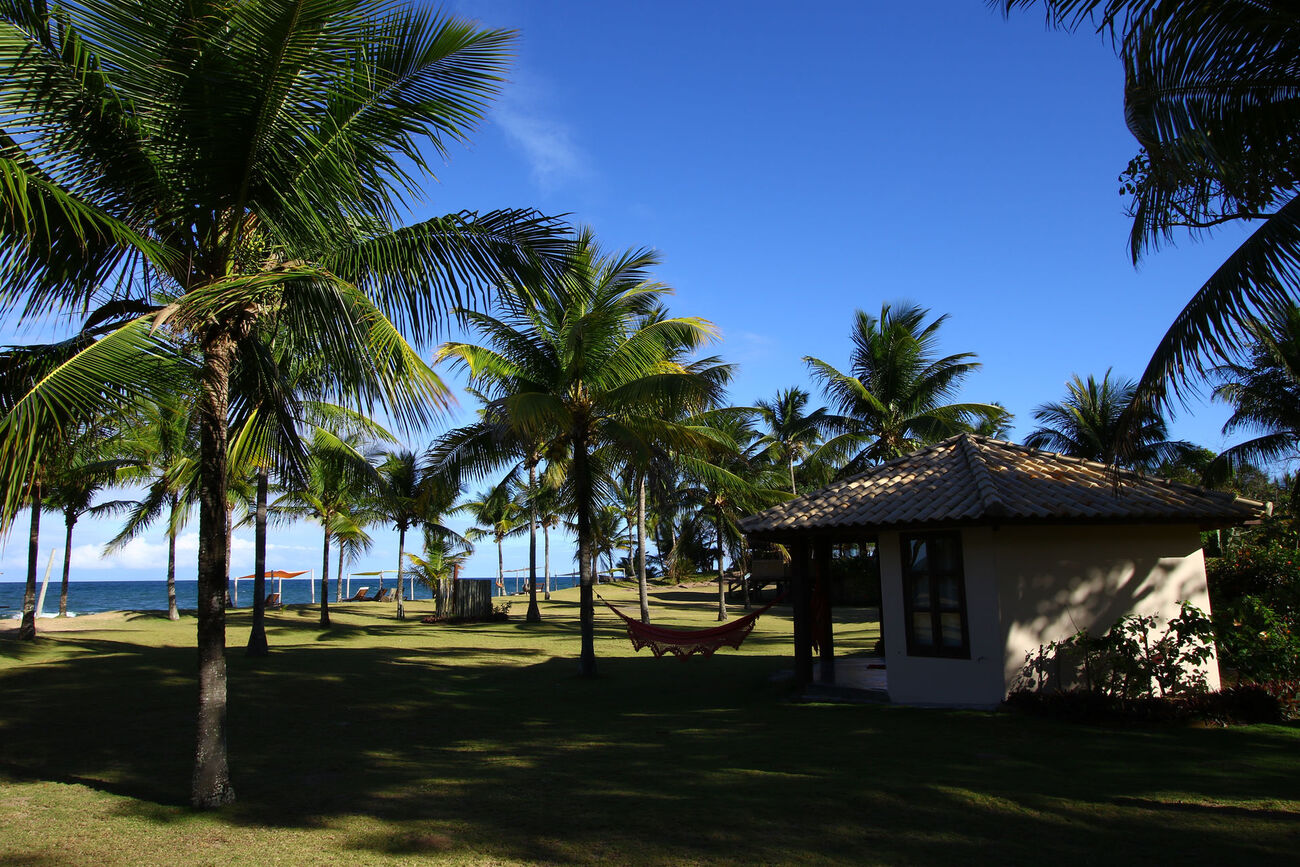 Bangalô em meio ao jardim com vista para a praia