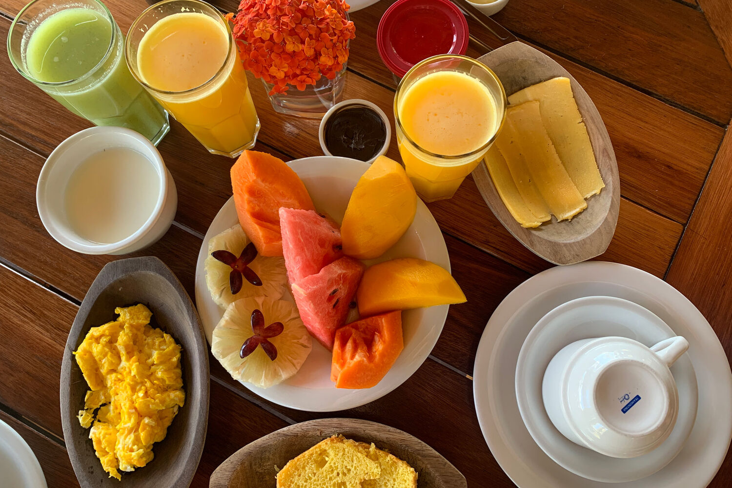 Café da manhã tropical com frutas, sucos e tapioca na pousada